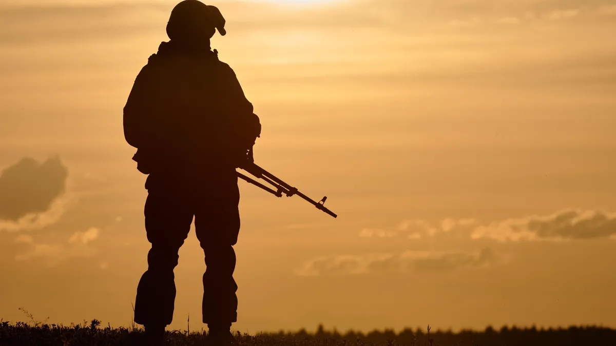 Military,Soldier,Silhouette,With,Machine,Gun,Over,Sunset