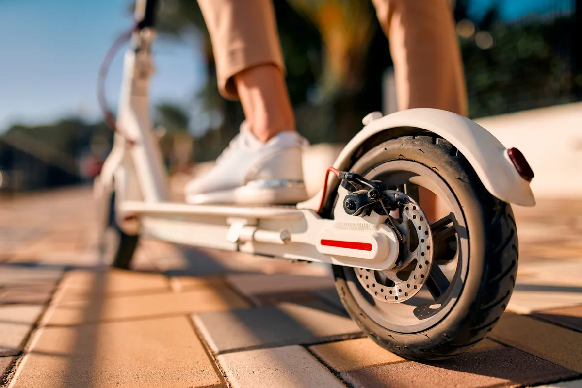 Close-up,Image,Of,Female,Feet,On,An,Electric,Scooter,,With